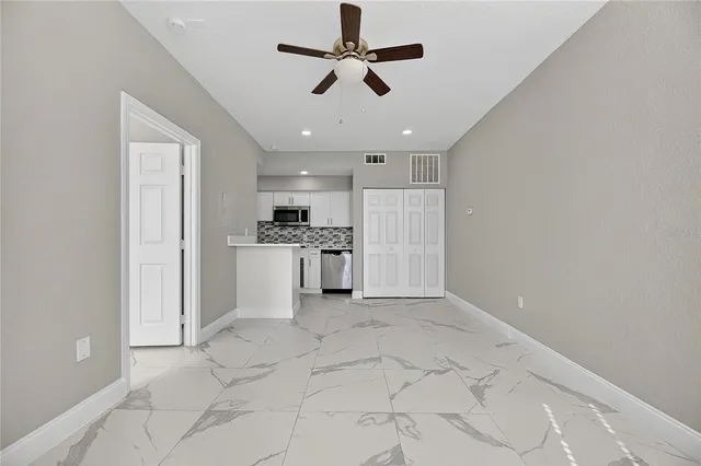 a view of a kitchen with refrigerator and a ceiling fan