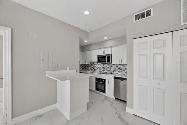 a kitchen with stainless steel appliances granite countertop a refrigerator and a sink