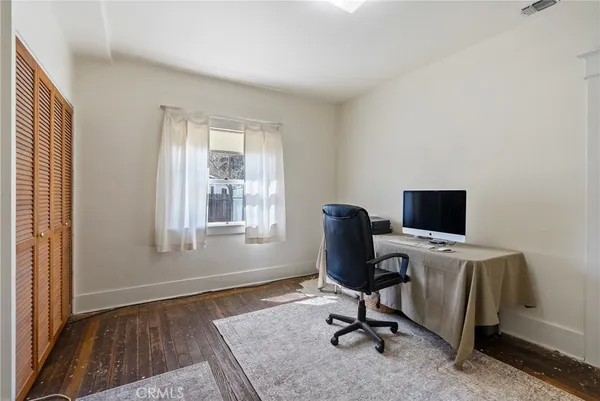 a view of a hallway with wooden floor and windows