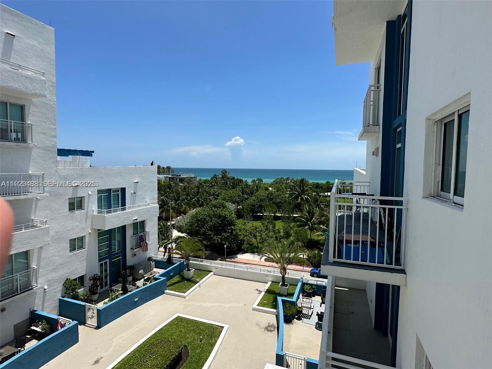 7600 Collins Avenue, Unit 709 Miami Beach, FL 33141 - Photo 2 of 4 a view of balcony with couches potted plants and wooden floor