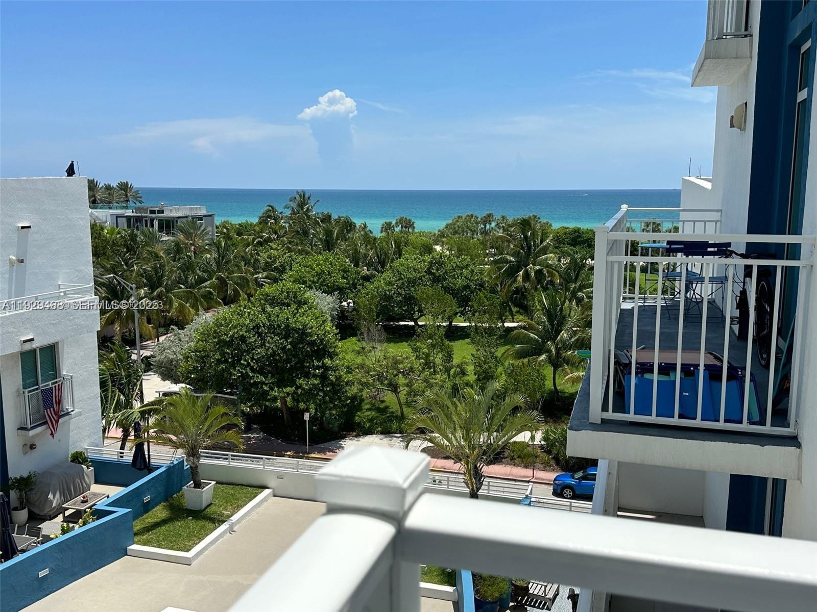 7600 Collins Avenue, Unit 709 Miami Beach, FL 33141 - Photo 3 of 4 a view of a patio with couches table and chairs with potted plants and big yard