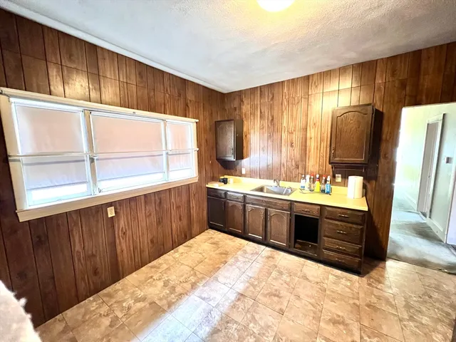 a kitchen with stainless steel appliances kitchen island granite countertop a sink stove and cabinets