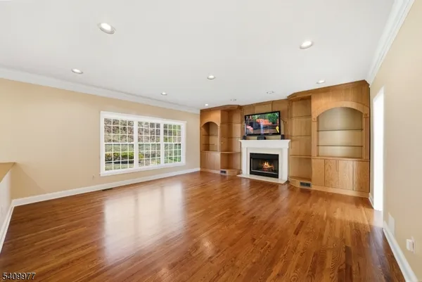 a view of a hallway with wooden floor and a fireplace