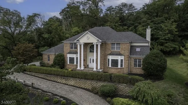 a front view of a house with a yard and green space