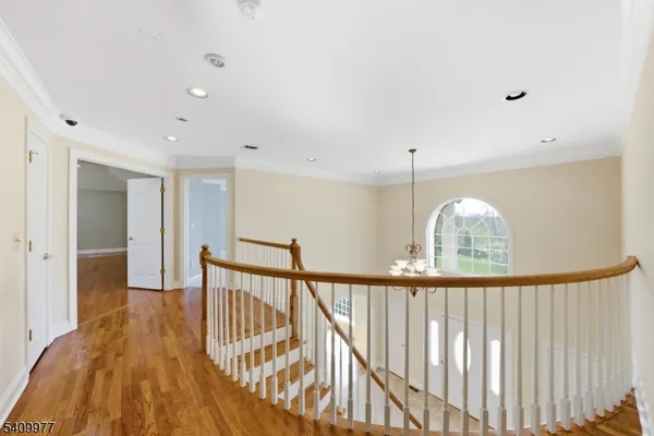 a view of hallway with wooden floor and stairs
