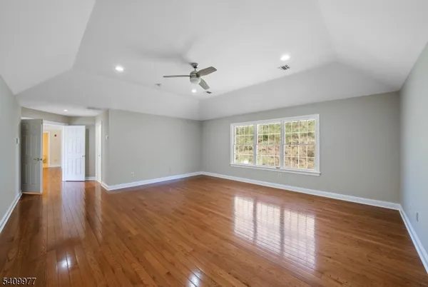 a view of empty room with wooden floor