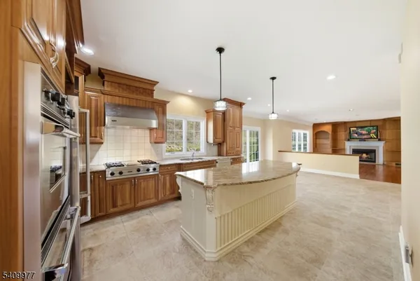 a large kitchen with stainless steel appliances granite countertop a stove and a refrigerator