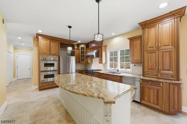a large kitchen with kitchen island a stove a sink and a refrigerator