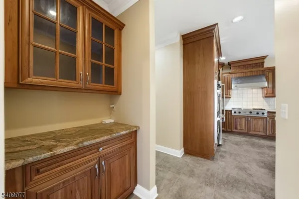 a view of kitchen with granite countertop cabinets and refrigerator