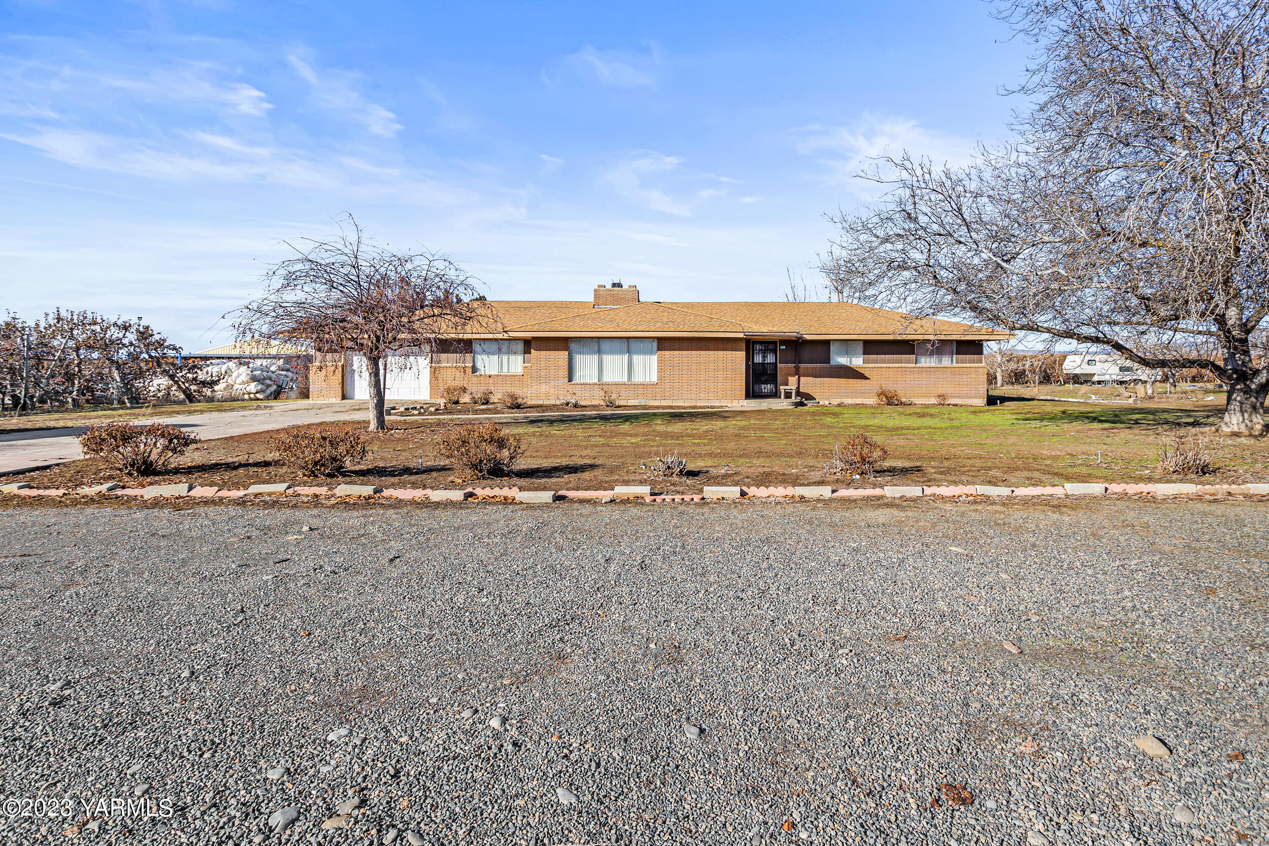 a front view of house with yard and trees in the background