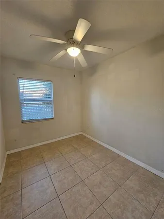 an empty room with a ceiling fan and a window