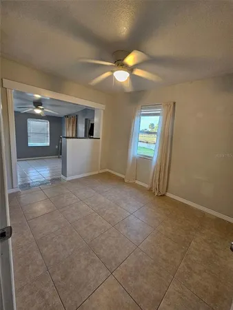 an empty room with windows and fireplace