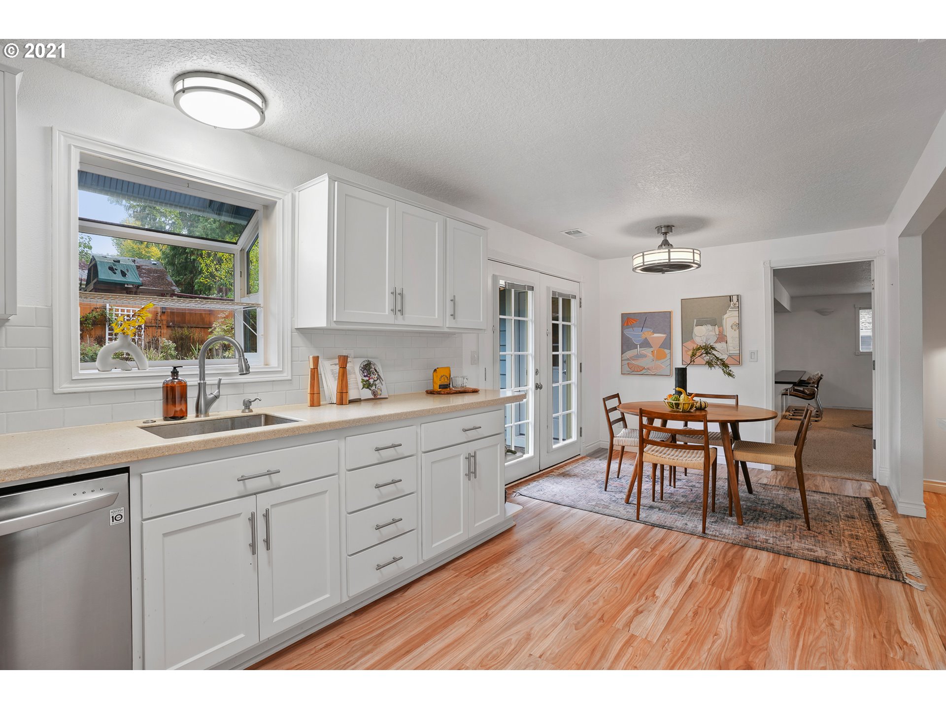 45 Southwest Collins Street Portland, OR 97219 - Photo 9 of 28 a open kitchen with granite countertop a dining table chairs and white cabinets