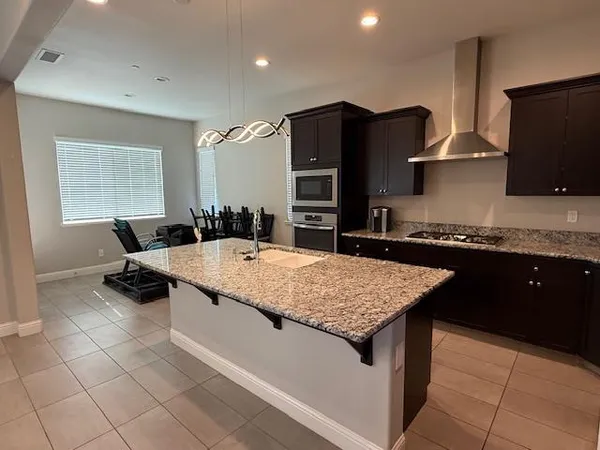 a kitchen with stainless steel appliances granite countertop a sink and a refrigerator