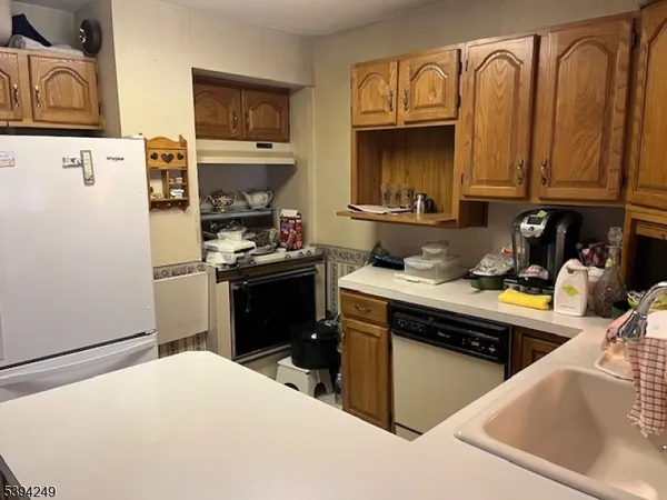 a kitchen with stainless steel appliances granite countertop a refrigerator stove top oven a sink and dishwasher