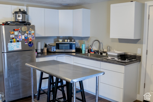 2269 Clear Creek Road Nibley, UT 84321 - Photo 16 of 27 Kitchen with stainless steel appliances, white cabinets, dark countertops, and a textured ceiling
