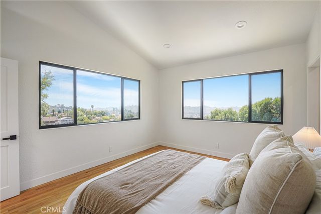 a bed sitting in a bedroom next to a window