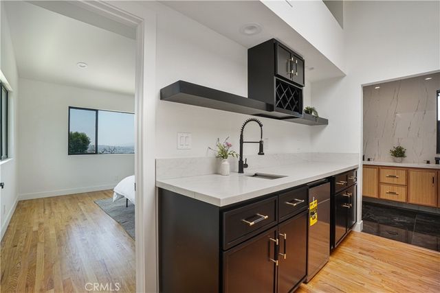 a kitchen with a sink dishwasher a stove and a microwave oven with wooden floor