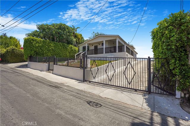 a view of a house with a small yard and wooden fence