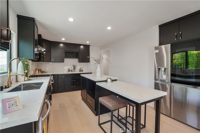 a kitchen with a table chairs sink and cabinets