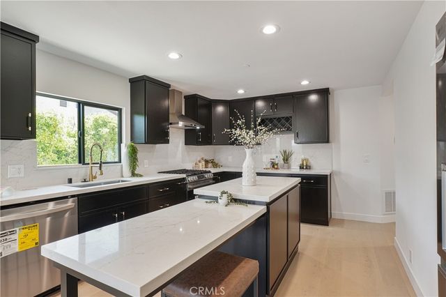 a kitchen with a sink a stove a refrigerator and blue cabinets