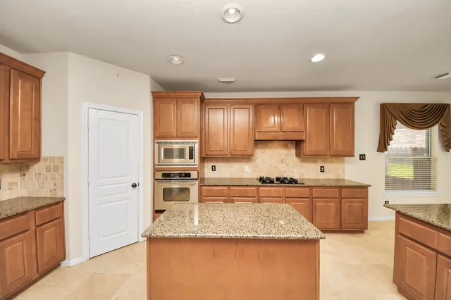 a kitchen with stainless steel appliances granite countertop sink stove and refrigerator