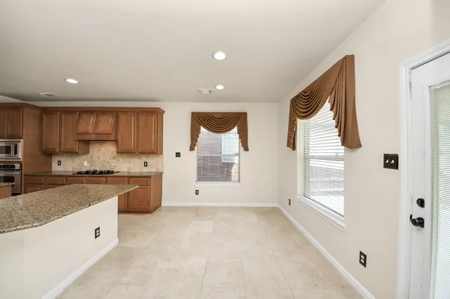 a spacious bathroom with a granite countertop sink a mirror and a shower