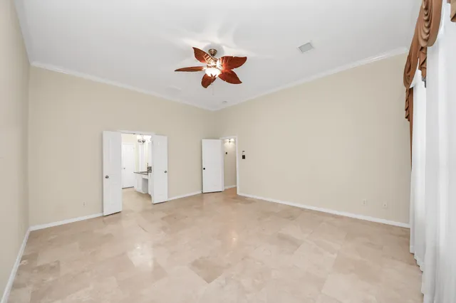 an empty room with a window and a ceiling fan