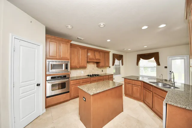 a kitchen with stainless steel appliances granite countertop a sink stove and refrigerator