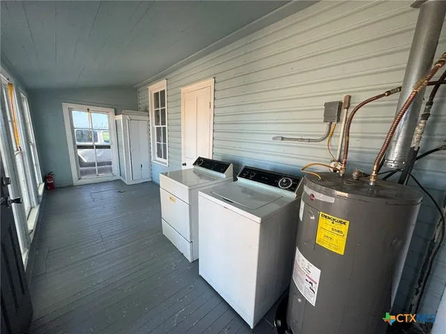 a view of kitchen with stainless steel appliances wooden floor and window