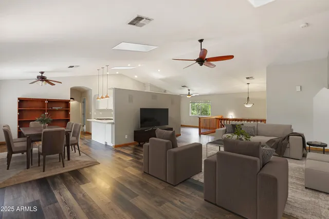 a living room with furniture a ceiling fan and a wooden floor