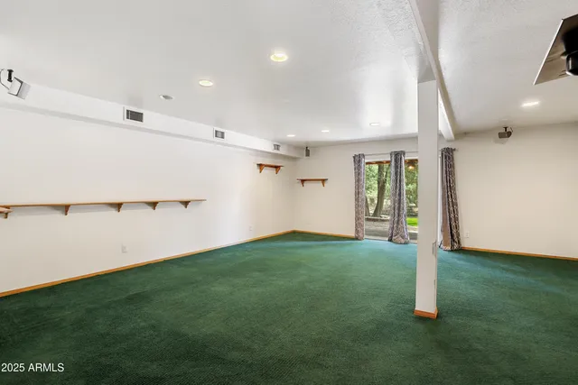 a view of a big room with wooden floor and windows
