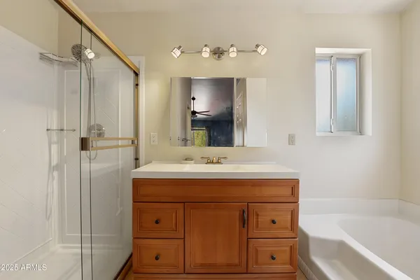 a bathroom with a sink vanity granite tub and shower