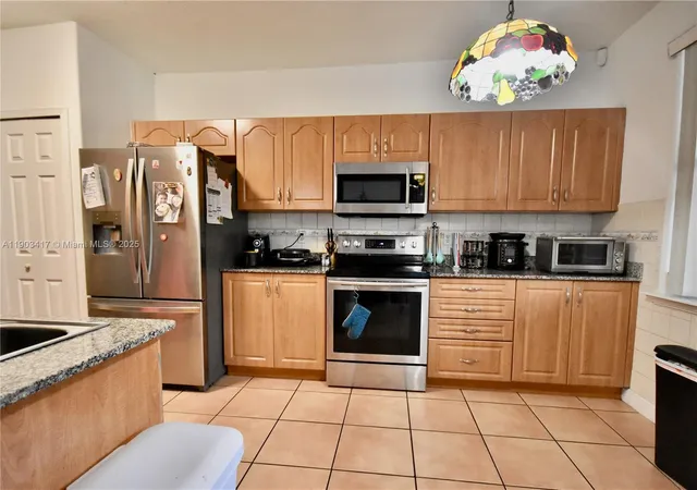 a kitchen with stainless steel appliances granite countertop a stove top oven a sink a counter top space and cabinets