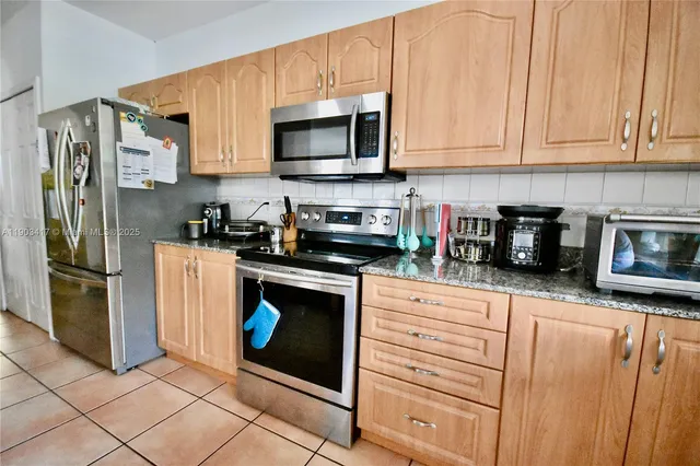 a kitchen with stainless steel appliances granite countertop a refrigerator stove and microwave