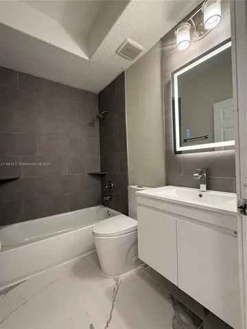 a bathroom with a toilet a sink and bathtub