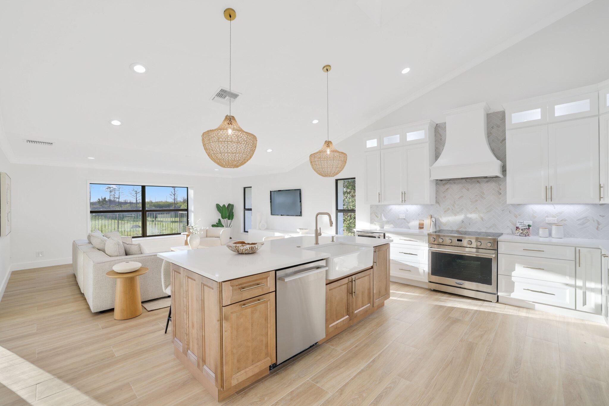 24 Dunbar Road Palm Beach Gardens, FL 33418 - Photo 29 of 93 a large kitchen with a stove a sink a refrigerator and a fireplace