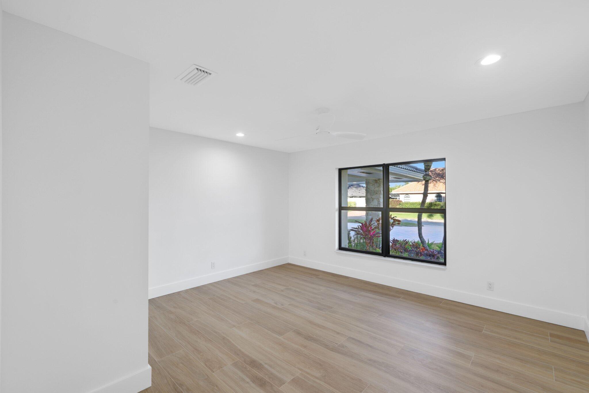 24 Dunbar Road Palm Beach Gardens, FL 33418 - Photo 51 of 93 an empty room with wooden floor and windows