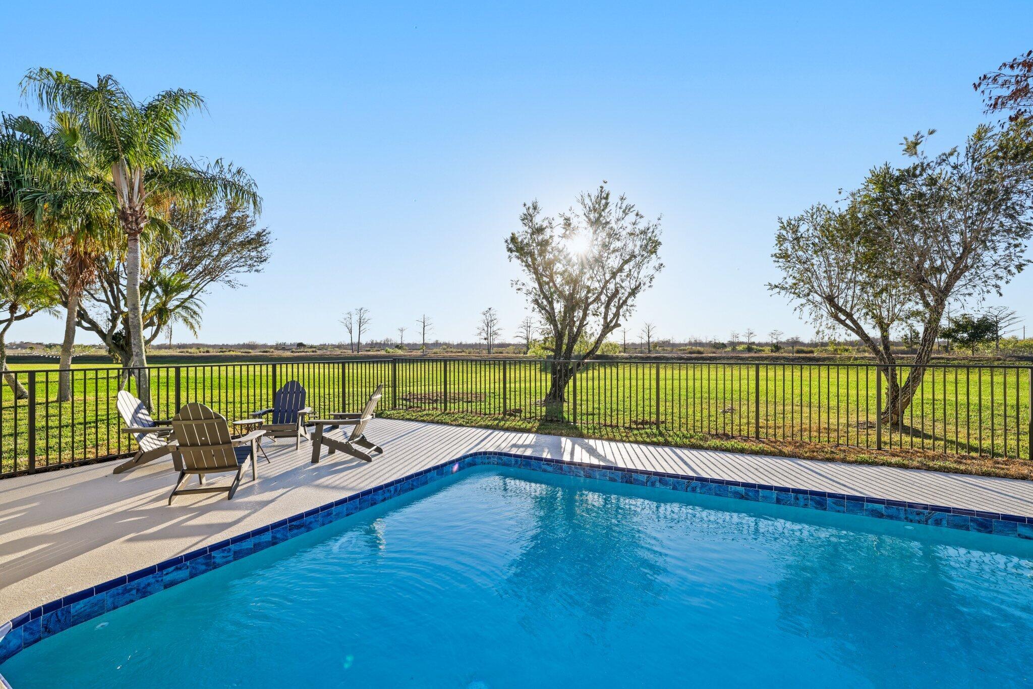 24 Dunbar Road Palm Beach Gardens, FL 33418 - Photo 63 of 93 a view of a swimming pool and lounge chairs