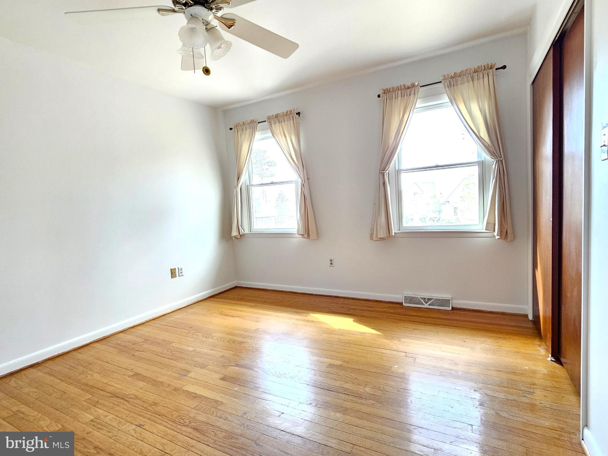 103 Shawnee Circle Cambridge, MD 21613 - Photo 32 of 49 an empty room with wooden floor and windows