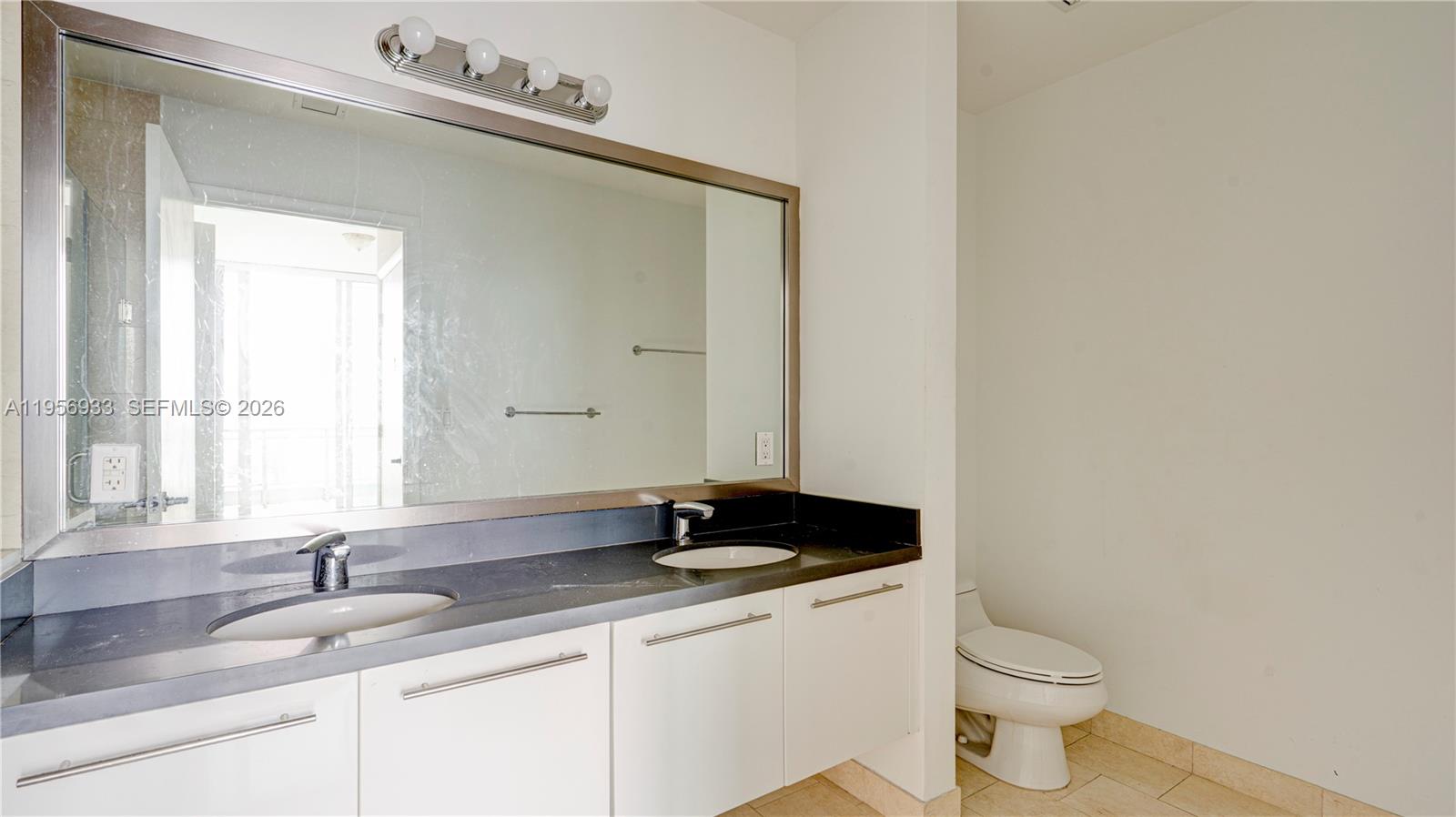 90 Southwest 3rd Street, Unit PH10 Miami, FL 33130 - Photo 14 of 31 a bathroom with a granite countertop sink and a toilet