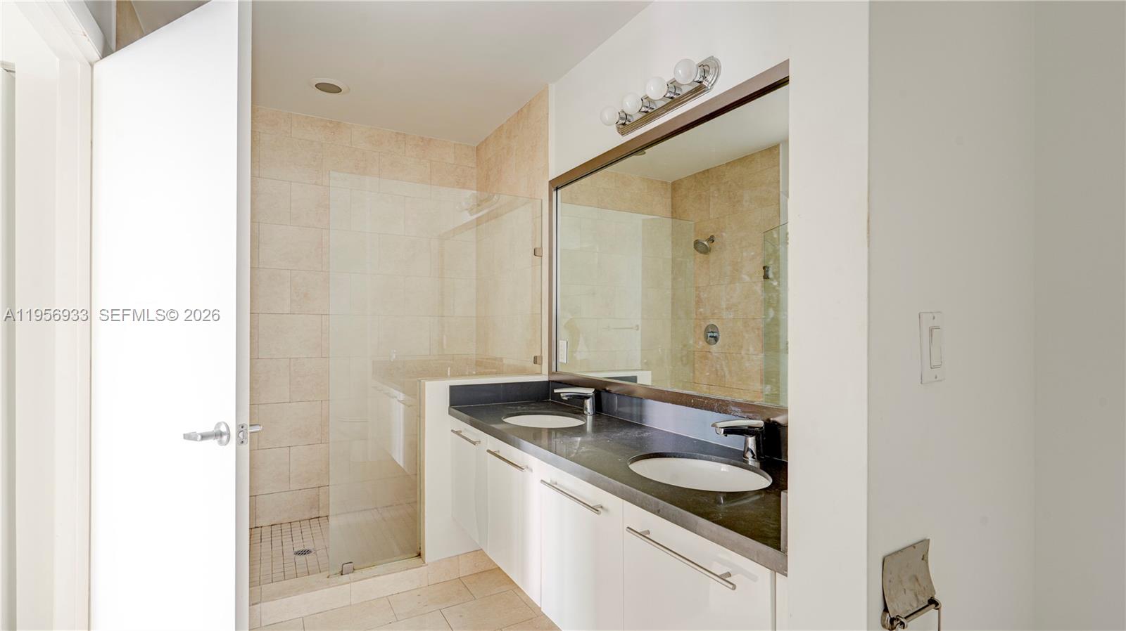 90 Southwest 3rd Street, Unit PH10 Miami, FL 33130 - Photo 15 of 31 a bathroom with a granite countertop sink and a mirror
