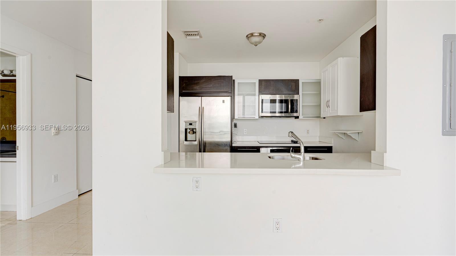 90 Southwest 3rd Street, Unit PH10 Miami, FL 33130 - Photo 16 of 31 a kitchen with stainless steel appliances a sink and a refrigerator