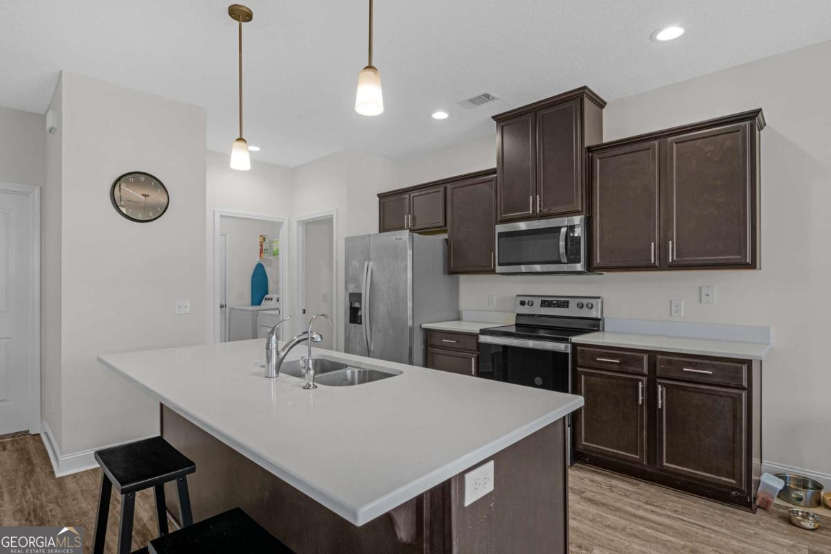 505 Rutledge Drive Hinesville, GA 31313 - Photo 18 of 24 a kitchen with stainless steel appliances a stove a sink a microwave a refrigerator and cabinets