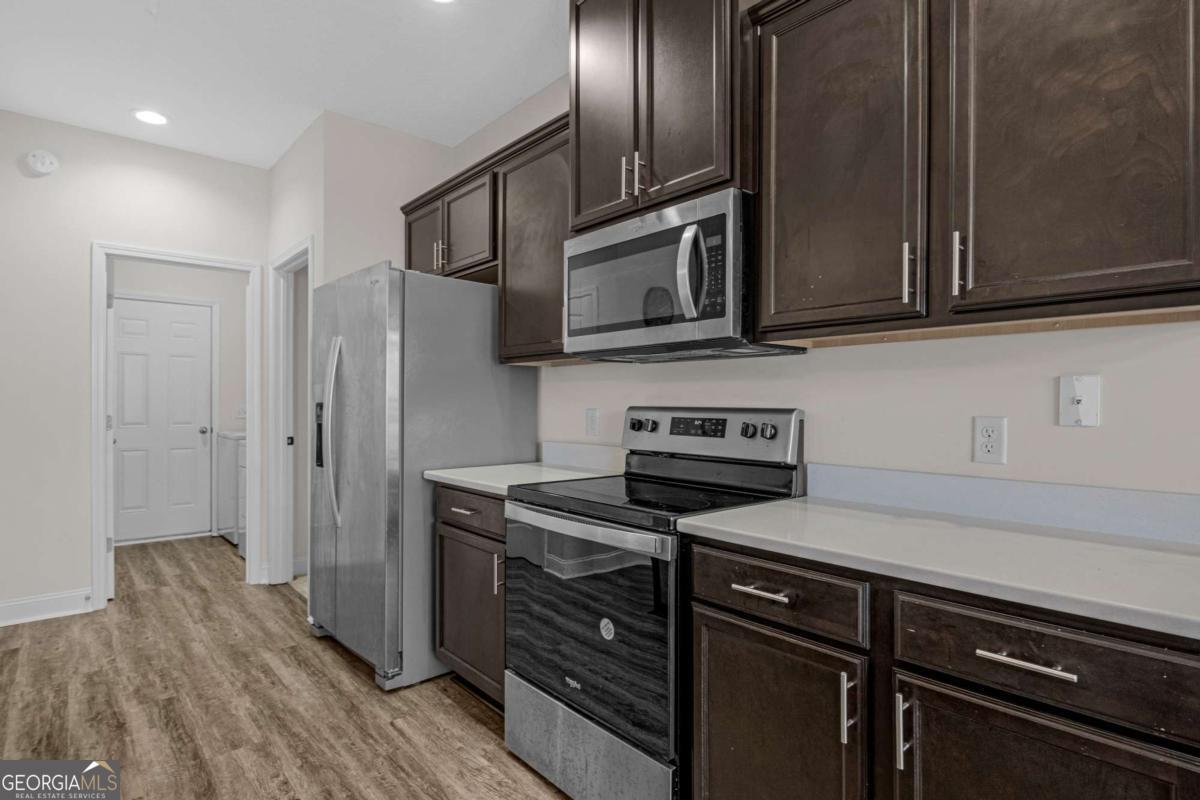 505 Rutledge Drive Hinesville, GA 31313 - Photo 19 of 24 a kitchen with stainless steel appliances granite countertop a stove microwave and refrigerator