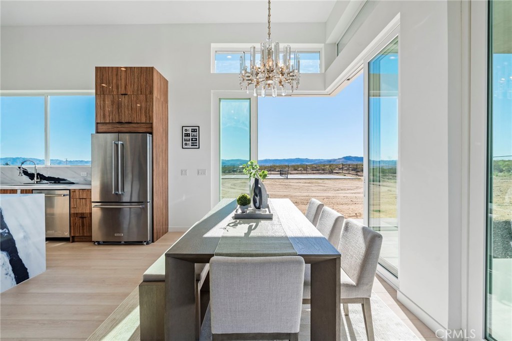 62050 Sonora Road Joshua Tree, CA 92252 - Photo 12 of 40 a view of a dining room with furniture a chandelier and wooden floor