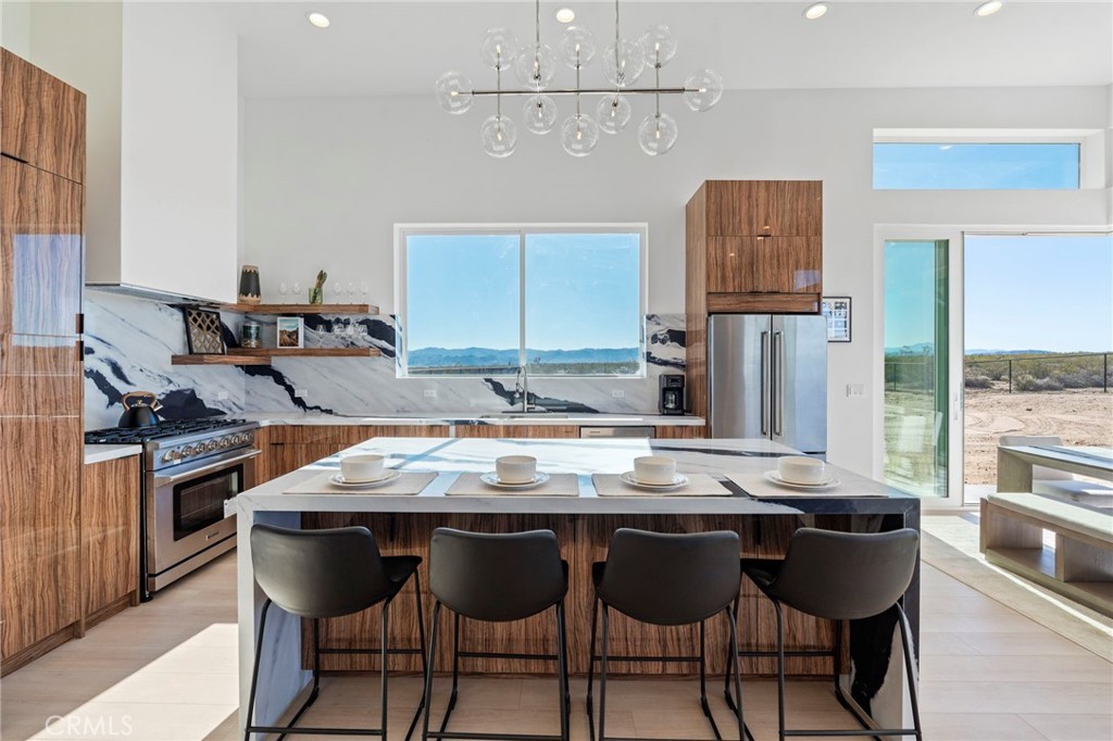 62050 Sonora Road Joshua Tree, CA 92252 - Photo 6 of 40 a kitchen with granite countertop a dining table chairs and stainless steel appliances