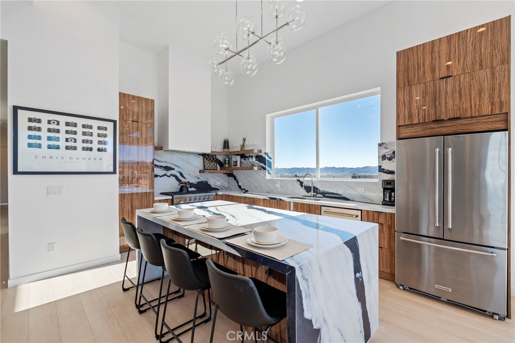 62050 Sonora Road Joshua Tree, CA 92252 - Photo 7 of 40 a kitchen with stainless steel appliances granite countertop a table chairs sink refrigerator and cabinets