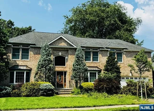 a front view of a house with a yard and potted plants