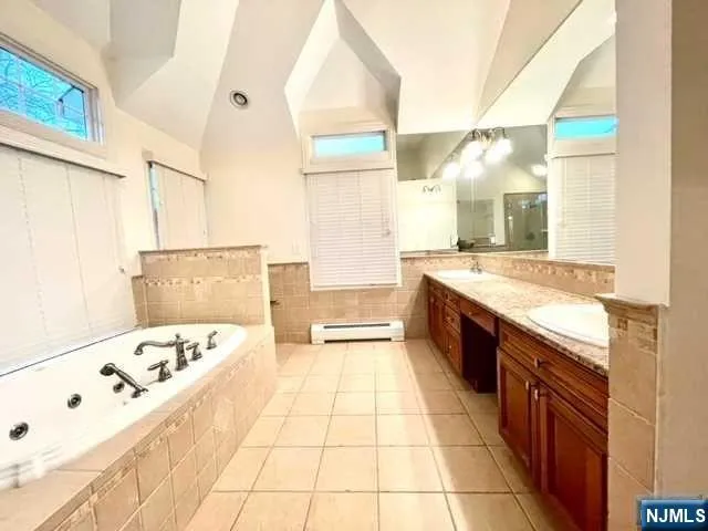 a large bathroom with a tub sink and mirror